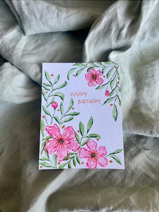 Birthday card with pink flowers and green foliage